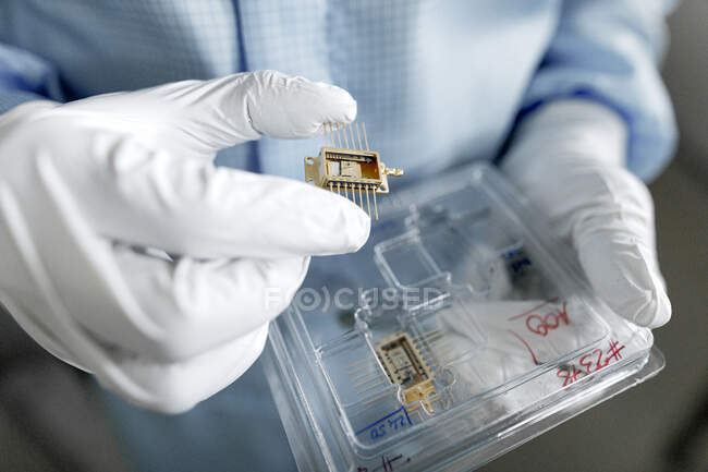 Hands of male scientist unpacking laser chips — Stock Photo