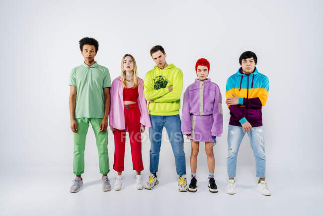 Группа крутых молодых людей в красочной одежде, стоящих на белом фоне — стоковое фото
