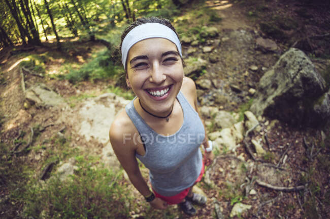 Lächelnde Frau mit Stirnband steht im Wald — Stockfoto