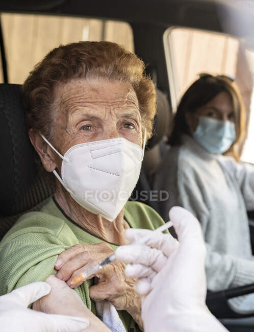 Mulher idosa a receber a injecção de COVID-19 de uma médica — Fotografia de Stock