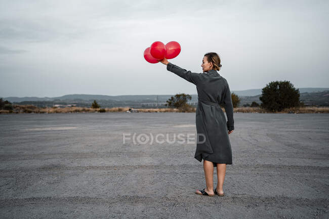 Femme adulte moyenne tenant un ballon debout sur la route — Photo de stock