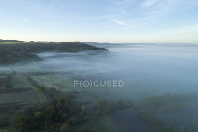 Vue par drone de la campagne entourée d'un épais brouillard à l'aube — Photo de stock