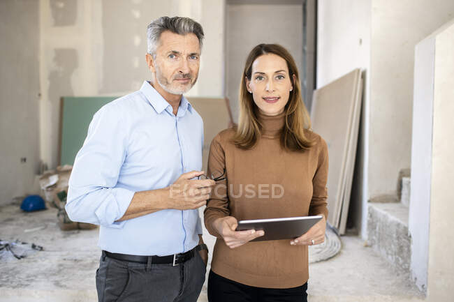 Коллега-женщина с цифровым планшетом рядом с красивым архитектором-мужчиной на месте — стоковое фото
