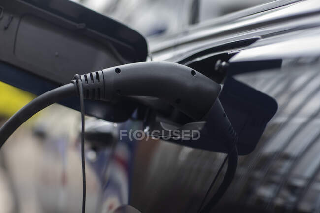 Carga de carro elétrico com cabo de alimentação preto — Fotografia de Stock