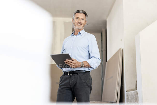 Profissional masculino com tablet digital no canteiro de obras — Fotografia de Stock