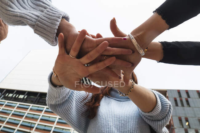 Jeunes amies empilant les mains — Photo de stock