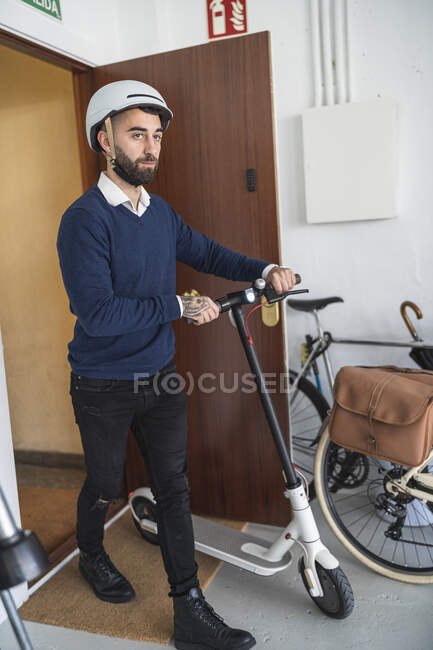 Empresario con scooter de empuje eléctrico llegando a la oficina - foto de stock