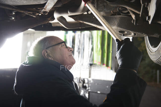 Mécanicien automobile mâle réparation de voiture dans l'atelier — Photo de stock