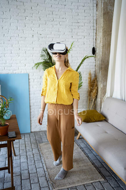 Woman wearing Virtual reality simulator while standing at home — Stock Photo