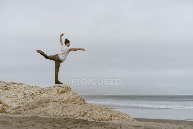 Jeune homme dansant sur le rocher à la plage de Point Reyes, Californie — Photo de stock
