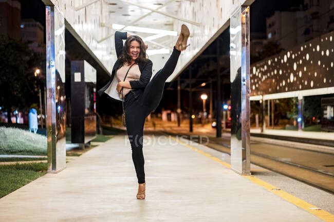 Mujer flexible bailando en la plataforma por la noche - foto de stock