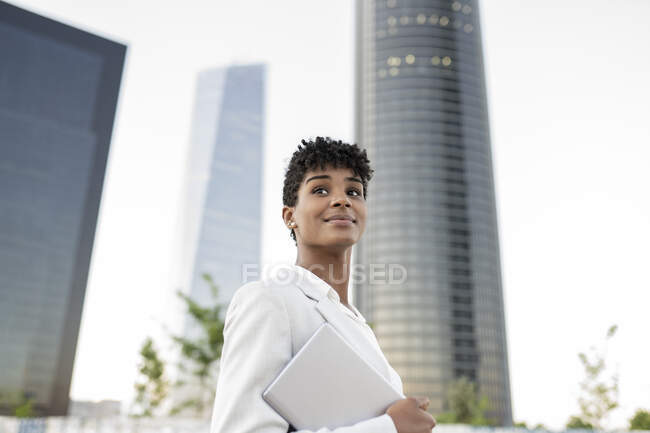 Feminino profissional de negócios olhando afastado segurando tablet digital na cidade — Fotografia de Stock