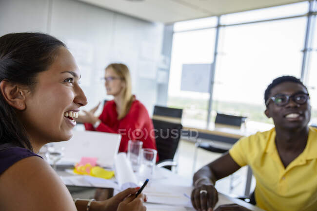 Lächelnde männliche und weibliche Berufstätige, die beim Treffen im Büro wegschauen — Stockfoto