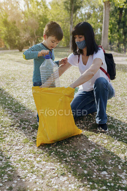 Mutter und Sohn reinigen Plastikmüll im Park — Stockfoto