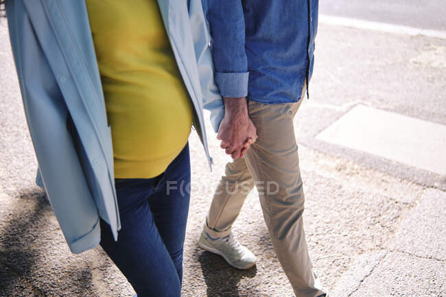 Schwangere hält Hand ihres Mannes beim Gehen auf der Straße — Stockfoto