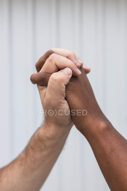 Homme tenant la main de la femme par un mur blanc — Photo de stock