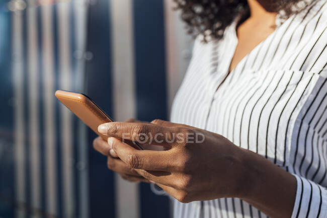 Mujer joven usando el teléfono inteligente durante el día soleado - foto de stock