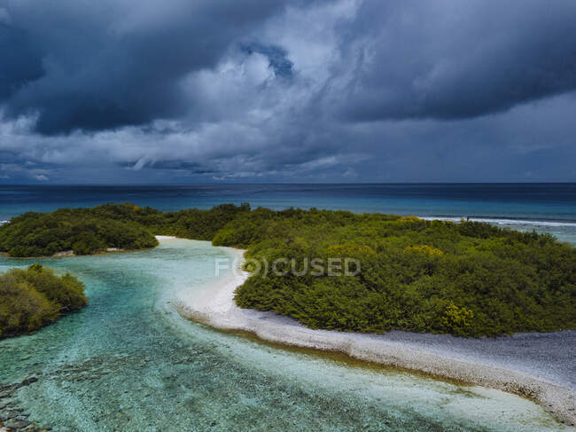 Árboles en la isla bajo el cielo nublado en Thulusdhoo Island, Kaafu atoll,  Maldivas — escénicas, Mar - Stock Photo | #493836274