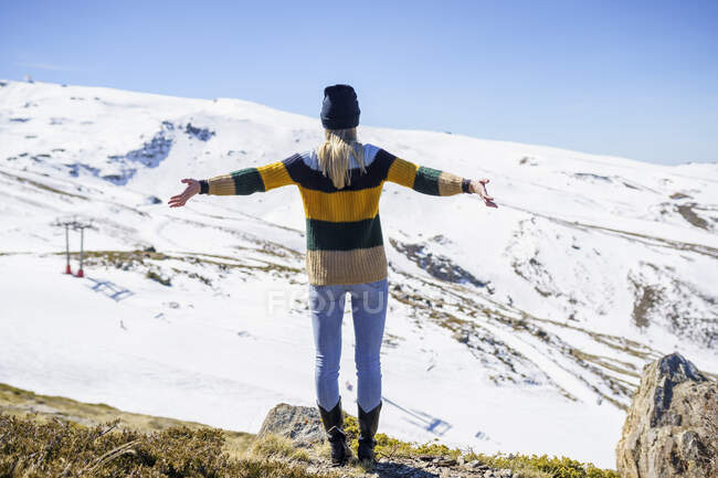 Donna con le braccia distese in piedi sulla montagna — Foto stock
