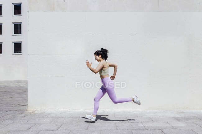Sportswoman running on footpath — Stock Photo