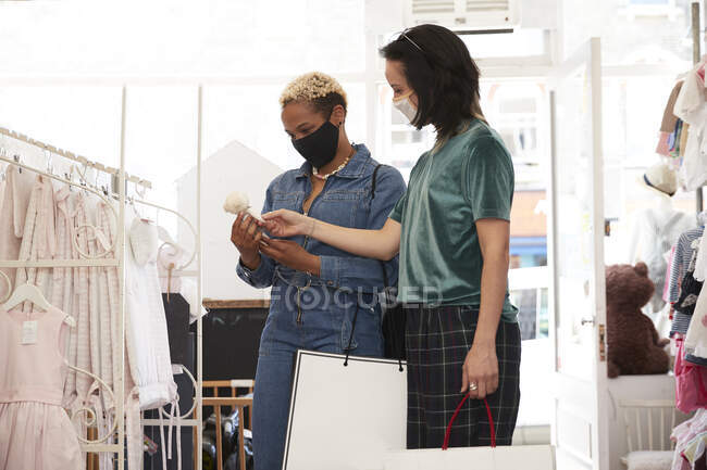 Amici donne con borse della spesa che scelgono giocattolo al negozio — Foto stock
