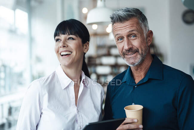 Smiling business couple standing together at coffee shop — Stock Photo