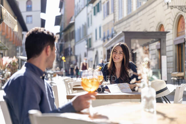 Touristin spricht Mann in Bürgersteig-Café an — Stockfoto