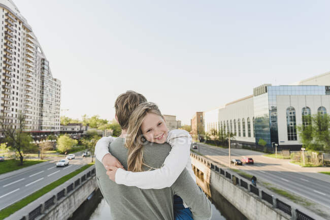 Smiling daughter embracing father in city — Stock Photo