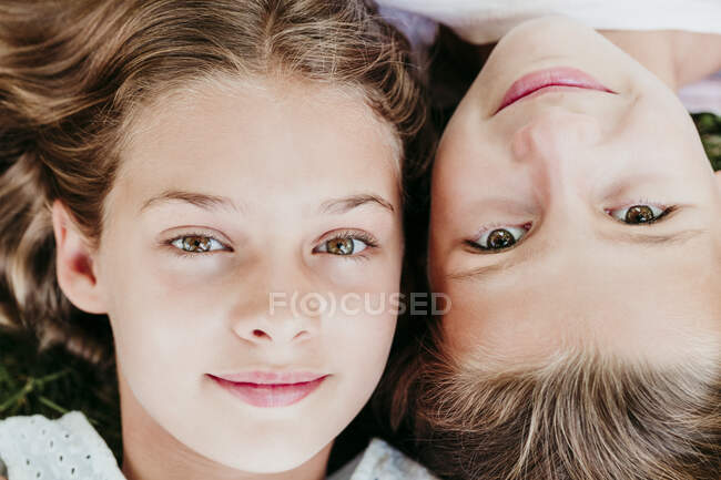 Souriantes filles couchées côte à côte — Photo de stock