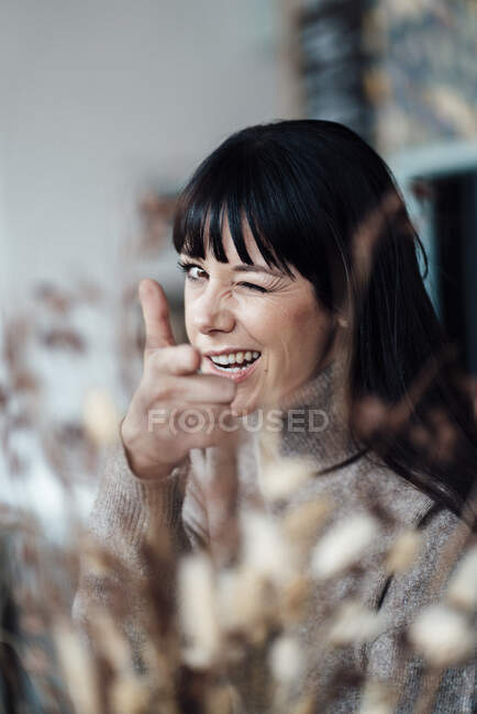 Жінка показує знак руки, коли робить обличчя в кафе. — стокове фото