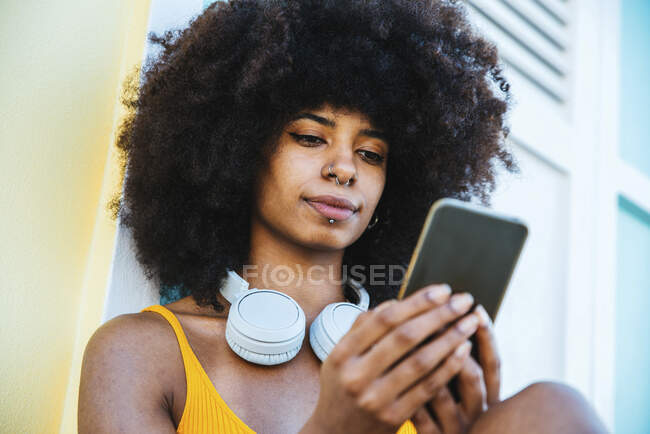 Giovane afro messaggistica donna attraverso il telefono cellulare — Foto stock