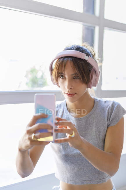 Junge Frau fotografiert mit Smartphone beim Musikhören — Stockfoto