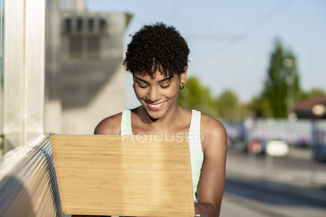 Молодая женщина использует ноутбук на открытом воздухе — стоковое фото