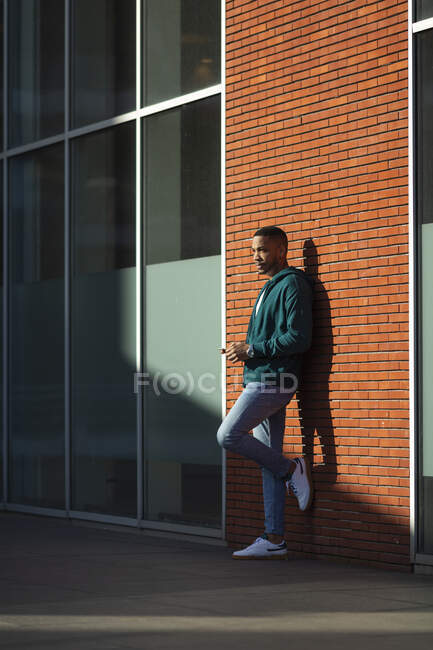 Young man looking away while leaning on wall — Stock Photo