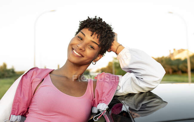 Young woman with head in hand standing near car — Stock Photo