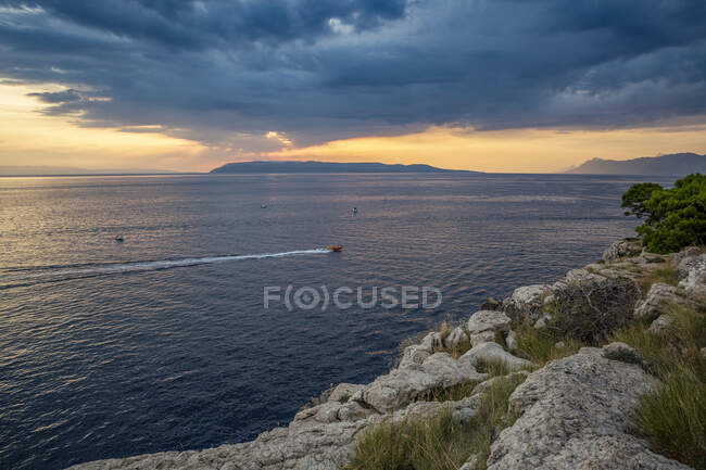 Barco à vela perto da costa em Makarska Riviera ao anoitecer nublado — Fotografia de Stock