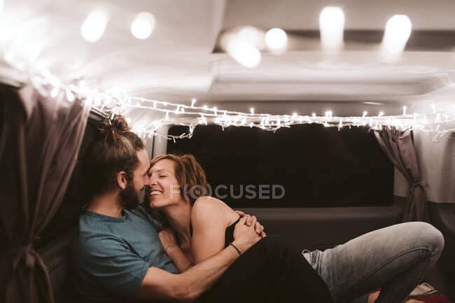 Couple romancing in illuminated van at night — Stock Photo