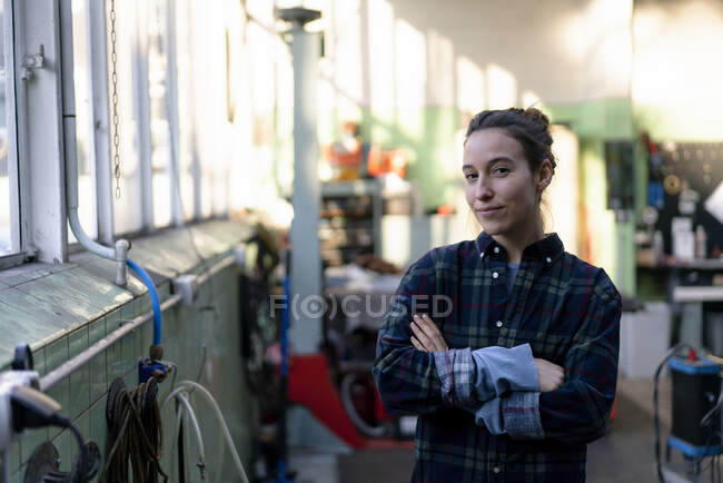 Mechanikerin mit verschränkten Armen in Werkstatt — Stockfoto