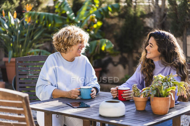 Щасливі жінки, що п'ють каву на подвір'ї. — стокове фото