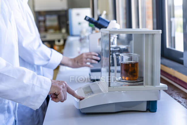 Female scientist weighing chemical on scale at laboratory — Stock Photo