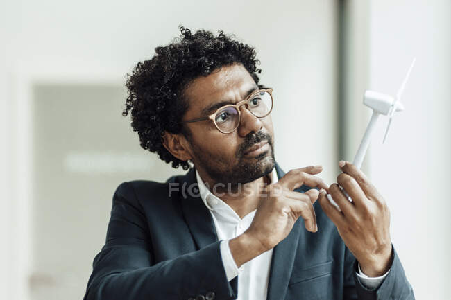 Male entrepreneur with curly hair examining wind turbine model in office — businessman, know how - Stock Photo | #495951224 Male entrepreneur with curly hair examining wind turbine model in office — businessman, know how - Stock Photo | #495951224