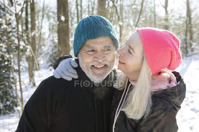 Rubia senior mujer sonriendo mientras besa hombre - foto de stock