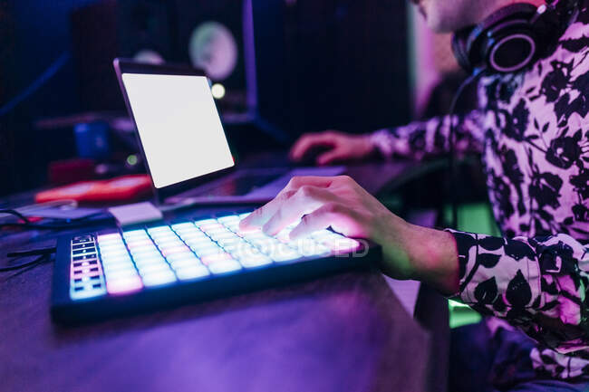 Compositeur masculin composant de la musique en utilisant un ordinateur portable et une tablette numérique au studio — Photo de stock