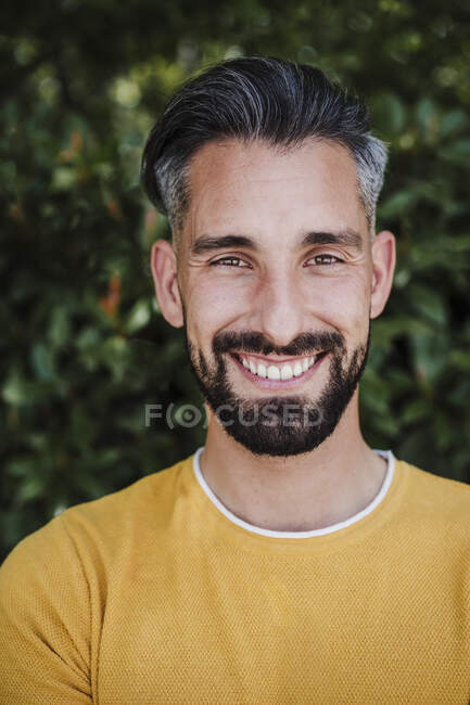 Bärtiger mittlerer Erwachsener lächelt im Park — Stockfoto