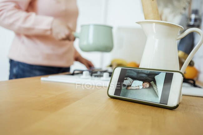 Woman preparing food during video call through mobile phone at kitchen — Stock Photo