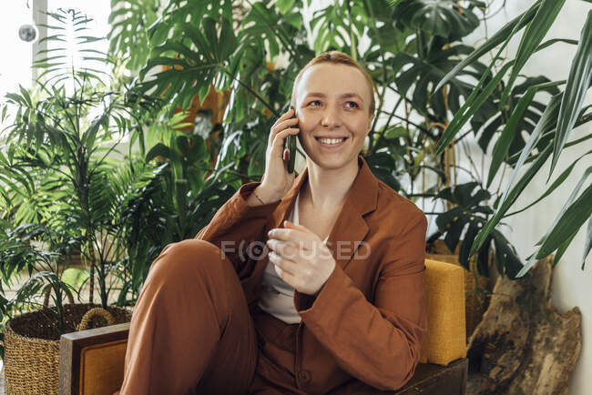 Imprenditrice sorridente che parla attraverso il cellulare sul posto di lavoro — Foto stock