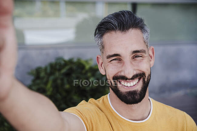 Homme souriant prenant selfie par téléphone intelligent — Photo de stock