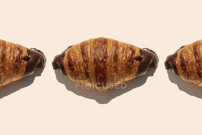 Tempting chocolate croissants on beige background — Stock Photo