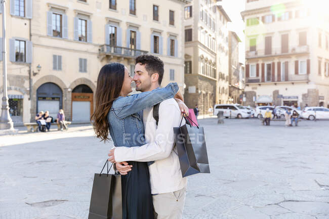 Couple holding shopping bags while standing face to face in city — Stock Photo