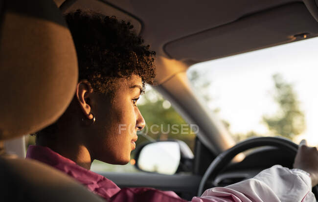 Молода жінка водить машину в сонячний день. — стокове фото